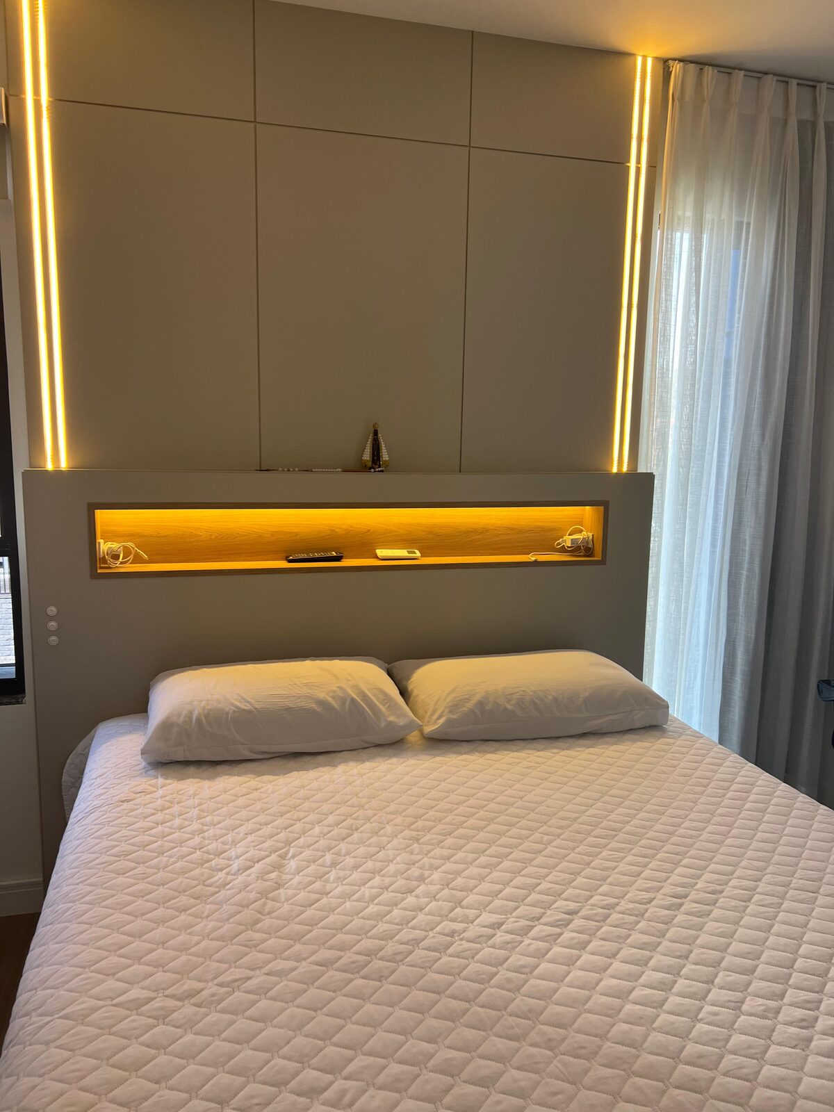 Quarto planejado com cabeceira em painel ripado e iluminação em LED — projeto Dádiva Marcenaria