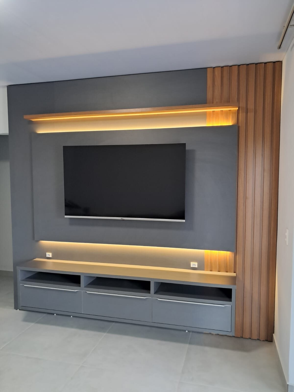 Painel de TV ripado com prateleira iluminada e rack suspenso