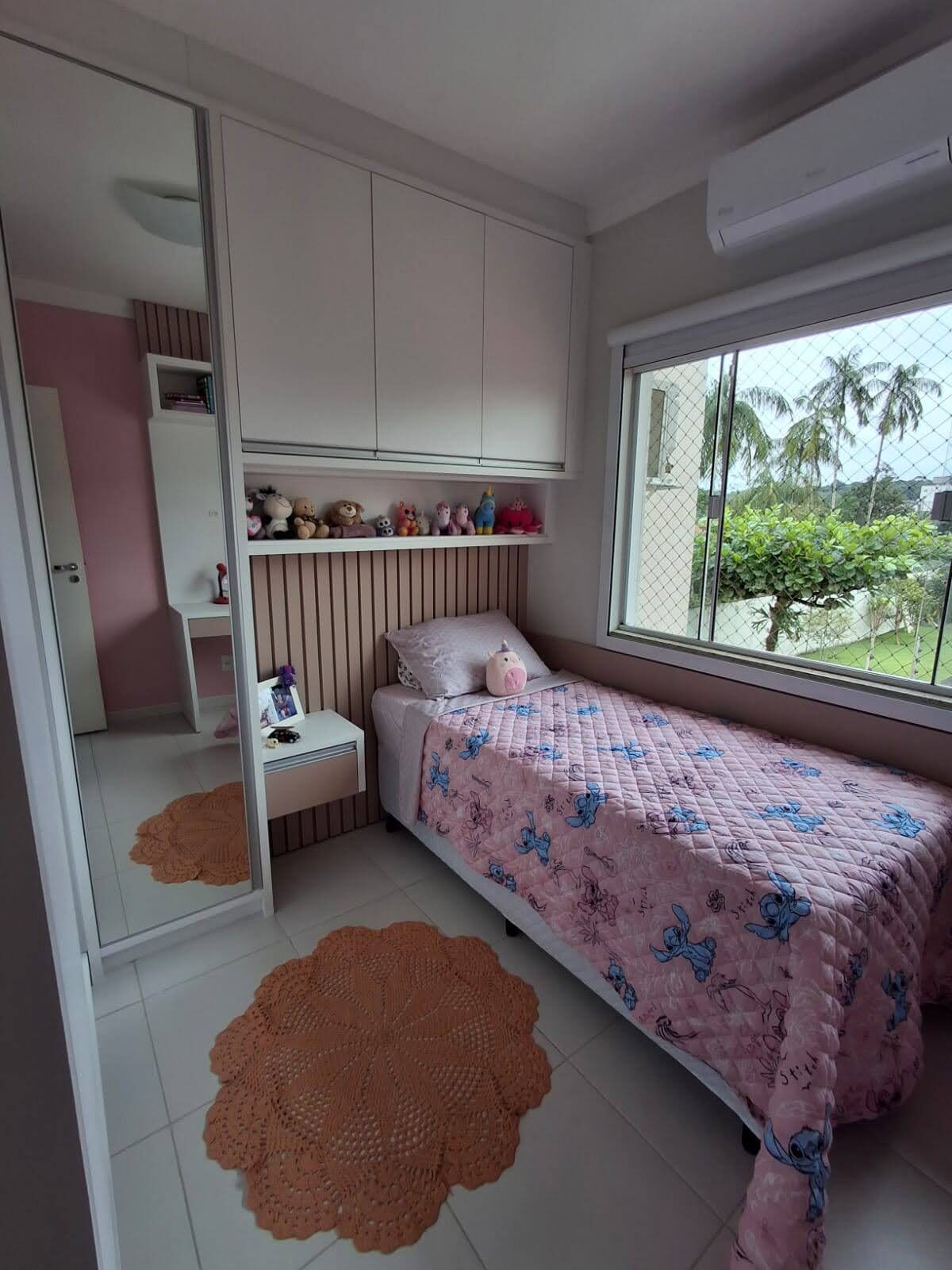 Quarto infantil planejado com armários, nichos e painel ripado rosa
